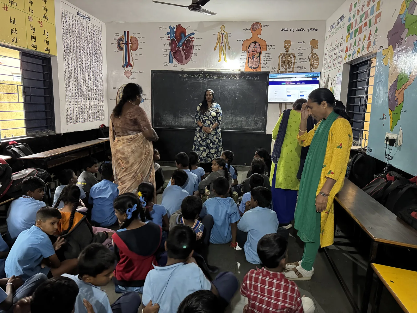 Students seated on the classroom floor during a SIFF session at a government school